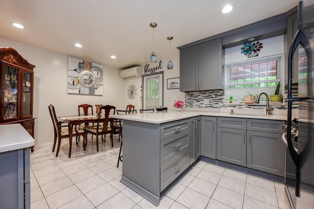 2588 Stedman Pl, Bronx, NY 10469 - kitchen featuring a wall unit AC, gray cabinets, a sink, a peninsula, and plenty of natural light