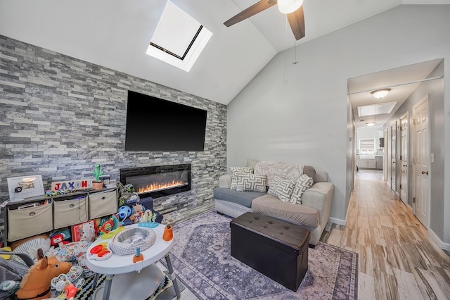 1203 Cross Bay Blvd, Broad Channel, NY 11693 - living area with lofted ceiling, a ceiling fan, a fireplace, a skylight, and wood finished floors