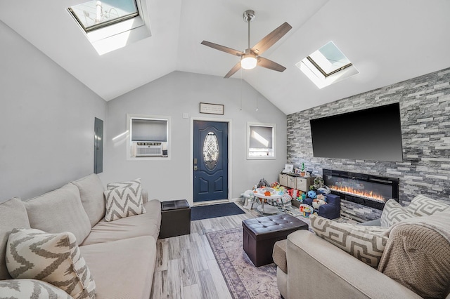 1203 Cross Bay Blvd, Broad Channel, NY 11693 - living room featuring a skylight, wood finished floors, a fireplace, vaulted ceiling, and cooling unit