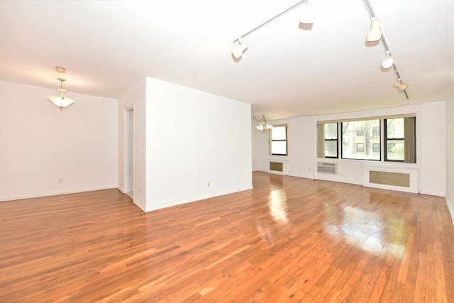 4 Birchwood Ct Unit 2K, Mineola, NY 11501 - spare room featuring track lighting, light wood-style flooring, and a chandelier