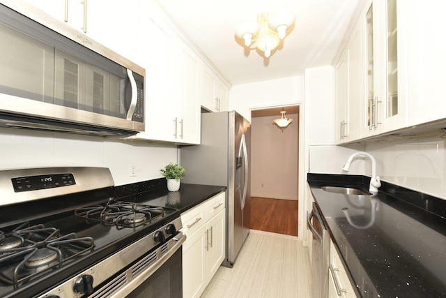 4 Birchwood Ct Unit 2K, Mineola, NY 11501 - kitchen with appliances with stainless steel finishes, a sink, white cabinetry, glass insert cabinets, and dark stone countertops