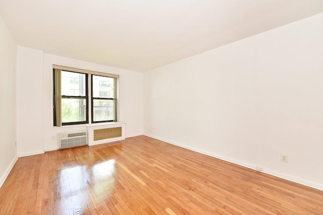 4 Birchwood Ct Unit 2K, Mineola, NY 11501 - empty room with light wood-style floors, a wall mounted AC, and baseboards