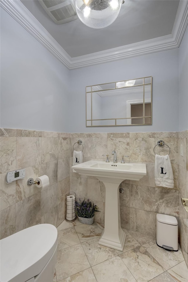 14 Rockwood Rd W, Manhasset, NY 11030 - half bathroom with tile walls, toilet, ornamental molding, wainscoting, and a sink