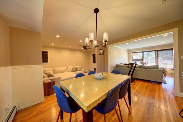 55 Richfield St, Plainview, NY 11803 - dining space with a baseboard radiator, light wood finished floors, a chandelier, a wainscoted wall, and recessed lighting