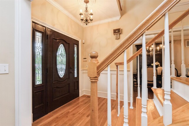 30 Lawrence Rd, Kings Park, NY 11754 - entrance foyer featuring stairs, ornamental molding, wood finished floors, a chandelier, and a wainscoted wall