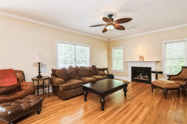 30 Lawrence Rd, Kings Park, NY 11754 - living area with light wood-type flooring, crown molding, a glass covered fireplace, ceiling fan, and baseboards