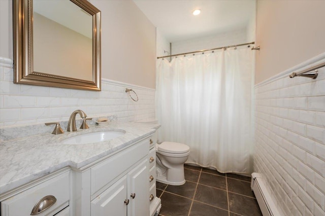 4200 Rocky Point Rd, East Marion, NY 11939 - bathroom with tile walls, a baseboard radiator, wainscoting, vanity, and tile patterned floors
