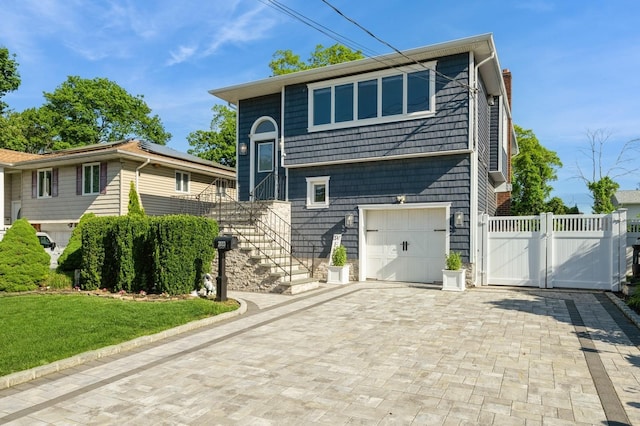 2033 Waltoffer Ave, North Bellmore, NY 11710 - bi-level home featuring a gate, decorative driveway, a garage, stairs, and a chimney