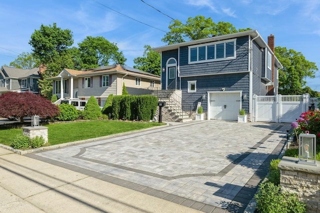 2033 Waltoffer Ave, North Bellmore, NY 11710 - bi-level home with a chimney, a gate, decorative driveway, an attached garage, and roof mounted solar panels