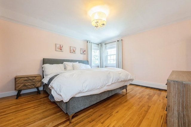 2033 Waltoffer Ave, North Bellmore, NY 11710 - bedroom with a baseboard radiator, light wood-type flooring, crown molding, and baseboards