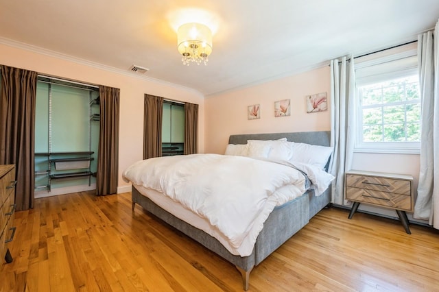 2033 Waltoffer Ave, North Bellmore, NY 11710 - bedroom with ornamental molding, light wood-type flooring, and a chandelier