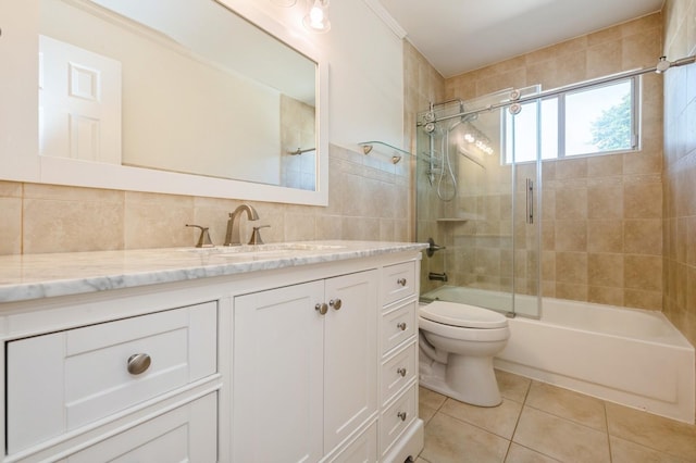 2033 Waltoffer Ave, North Bellmore, NY 11710 - bathroom with tile patterned floors, toilet, vanity, bath / shower combo with glass door, and tile walls