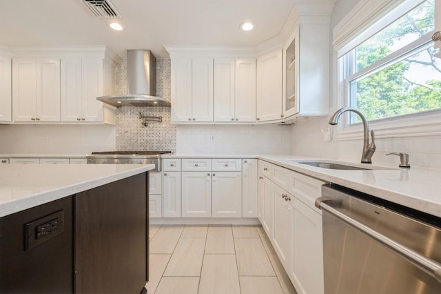 2033 Waltoffer Ave, North Bellmore, NY 11710 - kitchen featuring stainless steel appliances, wall chimney exhaust hood, a sink, white cabinets, and backsplash