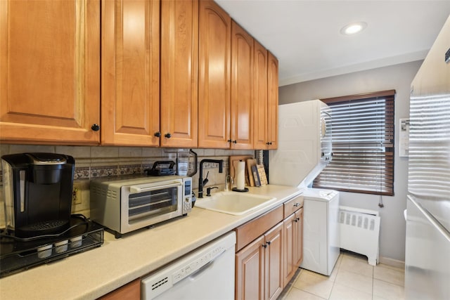 1213 E Broadway Unit B25, Hewlett, NY 11557 - kitchen featuring radiator, dishwasher, a sink, decorative backsplash, and stacked washing machine and dryer