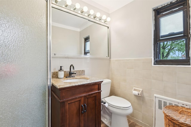 1213 E Broadway Unit B25, Hewlett, NY 11557 - bathroom with tile walls, toilet, radiator, vanity, and a wainscoted wall