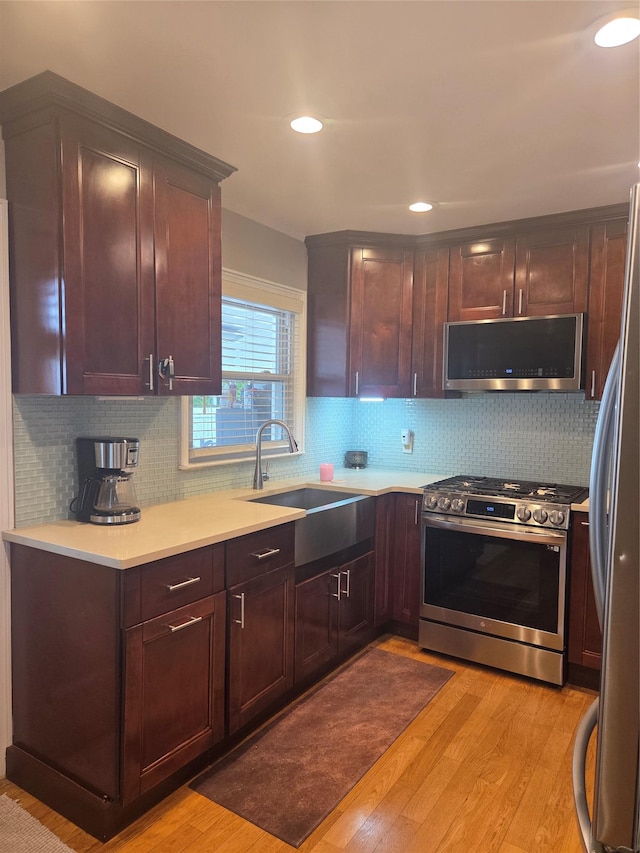 980 Alhambra Rd, North Baldwin, NY 11510 - kitchen featuring appliances with stainless steel finishes, light wood-style flooring, a sink, light countertops, and tasteful backsplash