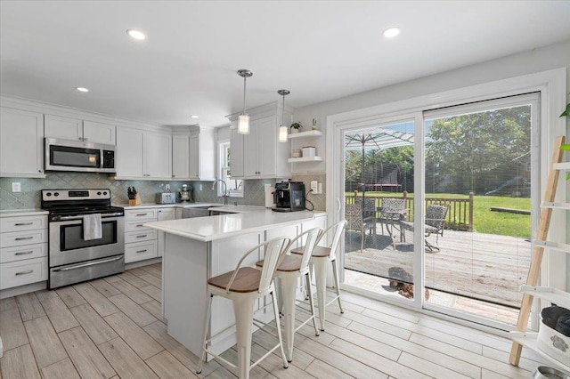 8 Meyer Ln, Medford, NY 11763 - kitchen with stainless steel appliances, open shelves, light countertops, backsplash, and a sink