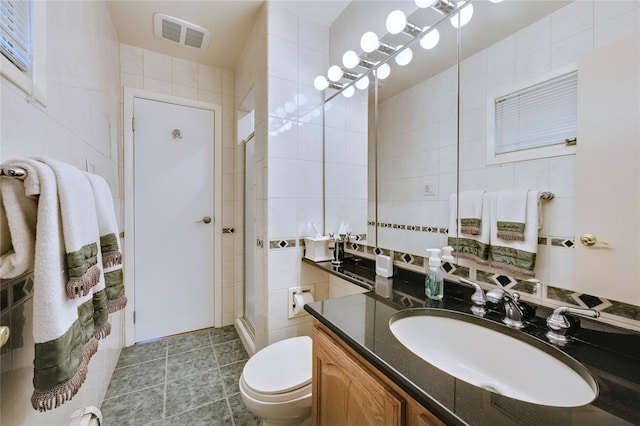 29 Cross Bow Ln, Commack, NY 11725 - full bathroom featuring tile walls, a stall shower, toilet, vanity, and tile patterned floors