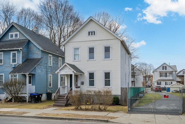 view of front facade with a gate, fence, and a residential view