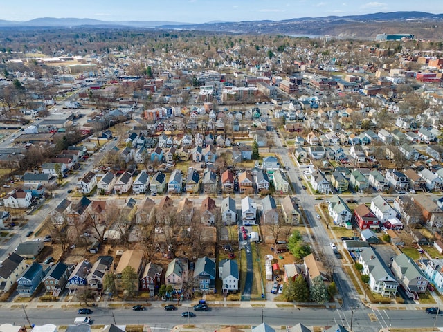 aerial view of property and surrounding area featuring a mountain backdrop and nearby suburban area