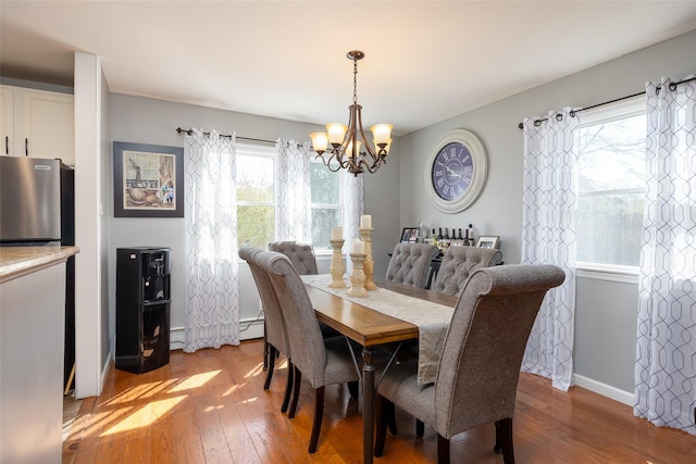17 Daytona Beach Pl, Coram, NY 11727 - dining area with a chandelier, light wood finished floors, a baseboard heating unit, and baseboards