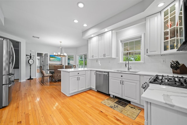 8 Roosa Rd, Wallkill, NY 12589 - kitchen with stainless steel appliances, a sink, a peninsula, a chandelier, and backsplash