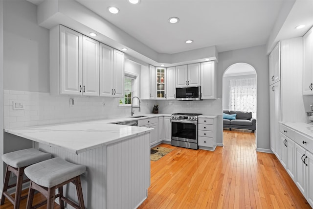 8 Roosa Rd, Wallkill, NY 12589 - kitchen with stainless steel appliances, a sink, arched walkways, a peninsula, and plenty of natural light