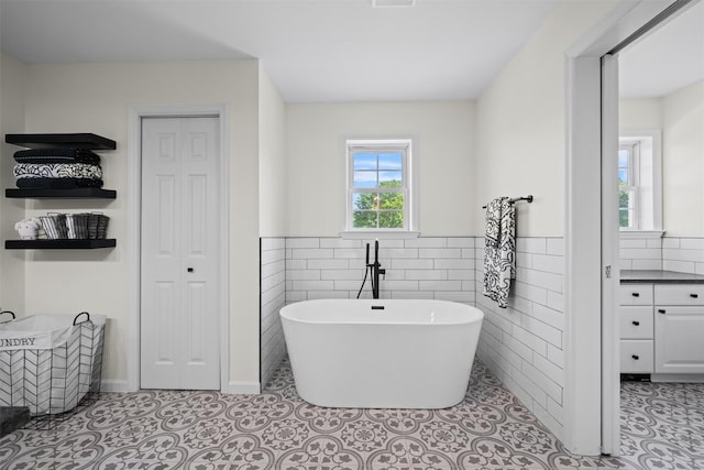 8 Roosa Rd, Wallkill, NY 12589 - bathroom with a soaking tub, wainscoting, tile walls, a closet, and vanity