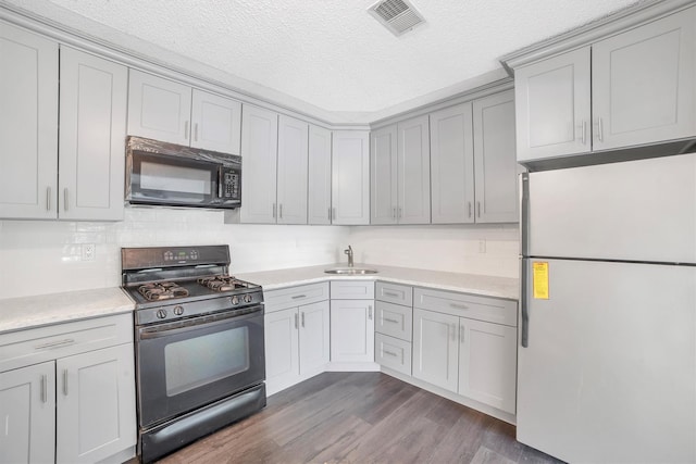 32 Huntington Cir Building 19, Peekskill, NY 10566 - kitchen with black appliances, a sink, light countertops, a textured ceiling, and dark wood-style flooring