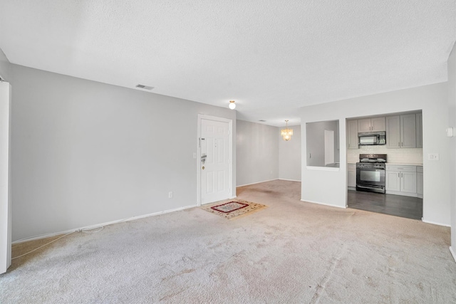 32 Huntington Cir Building 19, Peekskill, NY 10566 - unfurnished living room with carpet flooring, a chandelier, a textured ceiling, and baseboards