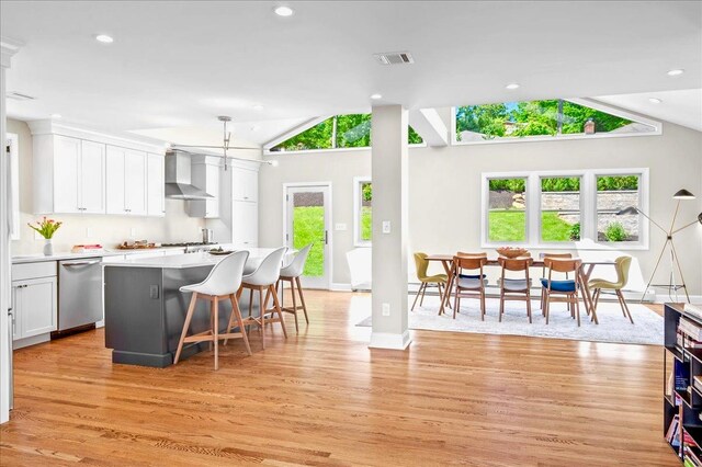 530 N Midland Ave N, Nyack, NY 10960 - kitchen featuring wall chimney exhaust hood, stainless steel dishwasher, lofted ceiling, light wood-style floors, and light countertops