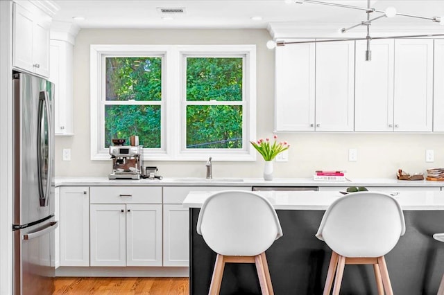 530 N Midland Ave N, Nyack, NY 10960 - kitchen featuring freestanding refrigerator, a kitchen bar, light countertops, a sink, and white cabinets