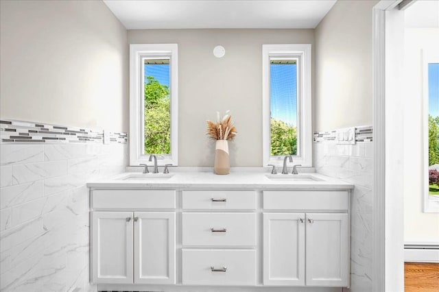 530 N Midland Ave N, Nyack, NY 10960 - bathroom with tile walls, double vanity, a wainscoted wall, and a baseboard heating unit