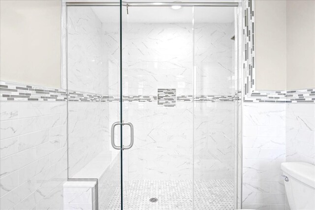 530 N Midland Ave N, Nyack, NY 10960 - full bathroom featuring tile walls, toilet, a stall shower, and wainscoting