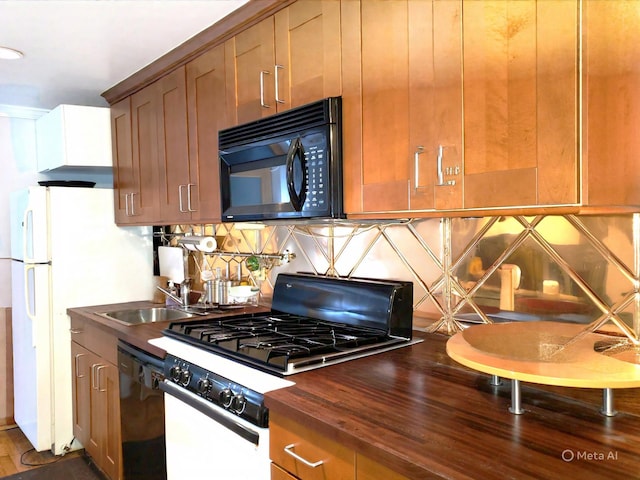 229 W 138th St, New York Manhattan, NY 10030 - kitchen with black appliances, backsplash, a sink, wood counters, and brown cabinetry