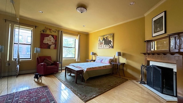 229 W 138th St, New York Manhattan, NY 10030 - bedroom with hardwood / wood-style floors, ornamental molding, recessed lighting, a baseboard radiator, and a fireplace