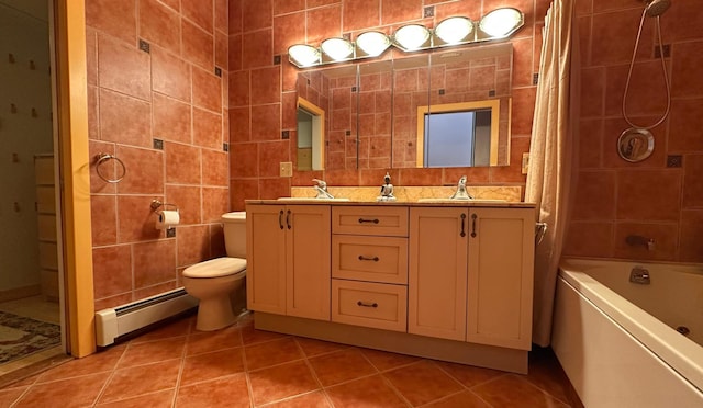 229 W 138th St, New York Manhattan, NY 10030 - bathroom featuring a baseboard heating unit, tile walls, double vanity, tile patterned flooring, and toilet