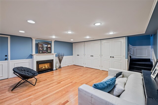 12 Horizon Ct Unit 103, Monsey, NY 10952 - living area featuring a decorative wall, light wood-type flooring, a fireplace with flush hearth, wainscoting, and recessed lighting