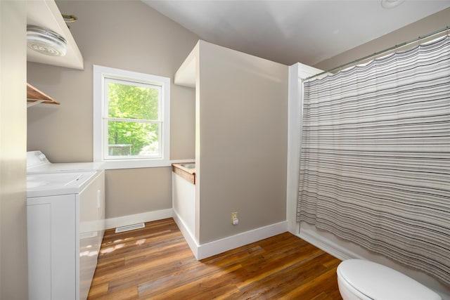 washroom with washer and clothes dryer, wood finished floors, and baseboards