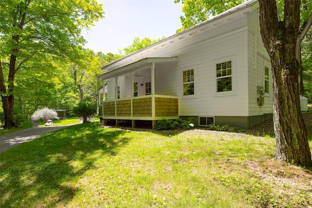back of house featuring ceiling fan and a yard