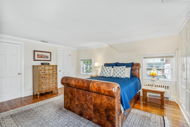 74 Eakins Rd, Manhasset, NY 11030 - bedroom with wood finished floors, crown molding, and radiator heating unit