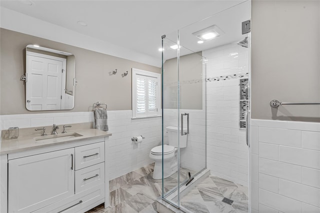 74 Eakins Rd, Manhasset, NY 11030 - bathroom featuring tile walls, a shower stall, vanity, a wainscoted wall, and marble finish floors