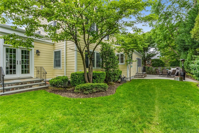 74 Eakins Rd, Manhasset, NY 11030 - view of grassy yard featuring french doors, a patio, and entry steps
