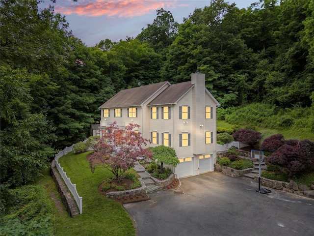 306 Mountain Rd, Pleasantville, NY 10570 - view of front facade featuring a chimney, asphalt driveway, an attached garage, and a wooded view