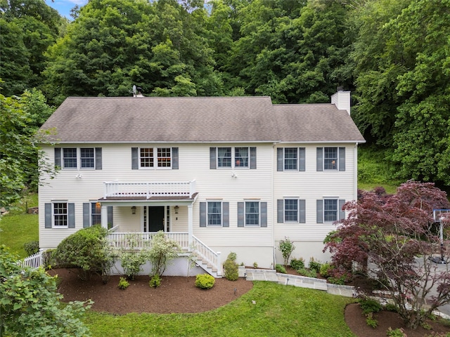 306 Mountain Rd, Pleasantville, NY 10570 - colonial-style house with a chimney, a front yard, covered porch, and roof with shingles