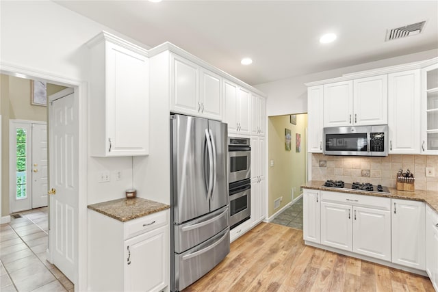 306 Mountain Rd, Pleasantville, NY 10570 - kitchen with appliances with stainless steel finishes, light stone countertops, white cabinetry, decorative backsplash, and recessed lighting