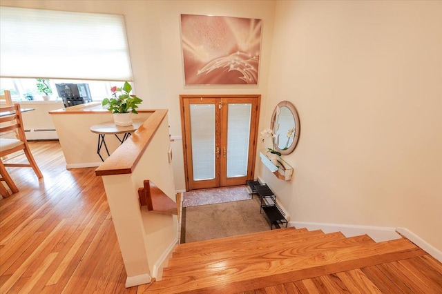 2083 Oliver Way, Merrick, NY 11566 - foyer with baseboard heating, light wood-type flooring, baseboards, and french doors