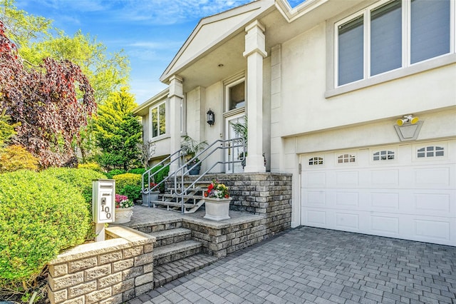 100 Mark Ln, Atlantic Beach, NY 11509 - entrance to property featuring stucco siding, decorative driveway, stone siding, and an attached garage