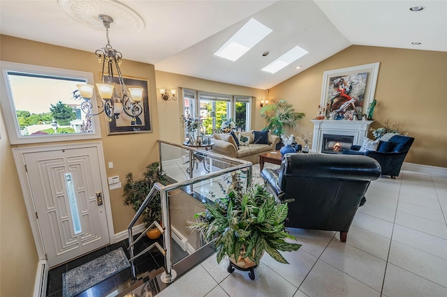 100 Mark Ln, Atlantic Beach, NY 11509 - tiled foyer with vaulted ceiling, baseboards, a chandelier, a glass covered fireplace, and a skylight