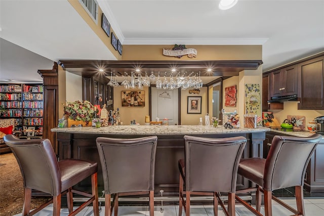 100 Mark Ln, Atlantic Beach, NY 11509 - indoor wet bar featuring under cabinet range hood, light tile patterned flooring, and ornamental molding